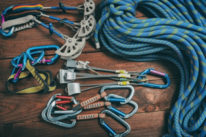 Paracord factory: Blue paracord with yellow stripes and other outdoor gear on a wooden table.