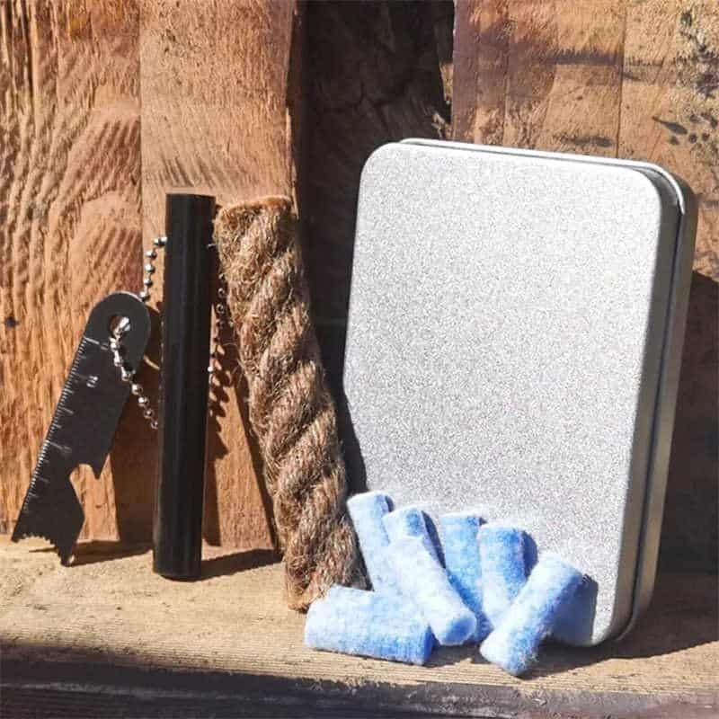 Complete fire starter kit featuring ferro rod bulk FRC20, multi-tool scraper, wax jute rope, and tinder cotton in a metal storage tin.