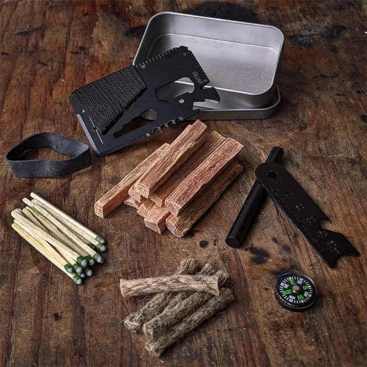 FRC17 ferro rod bulk kit featuring a premium fire starter, tactical multi-tool card, and waterproof tinder in a compact metal storage case for outdoor survival.