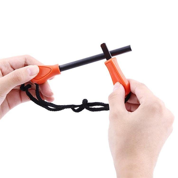 Close-up of hands using the FRC26 premium ferrocerium rods kit with an orange handle and multi-tool striker for wholesale buyers.