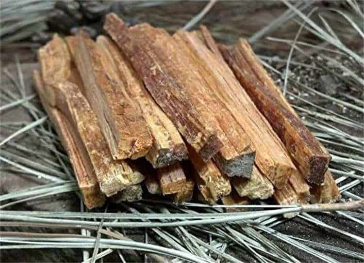 Close-up of natural fatwood tinder sticks and wax-infused hemp wick, ideal for use with high-quality bulk fire steel tools.