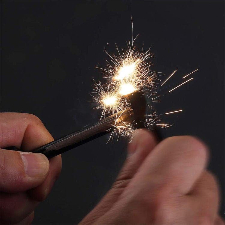 High-heat 3,000°C spark shower produced by striking a wholesale ferro rod to ignite campfire tinder in the wild.