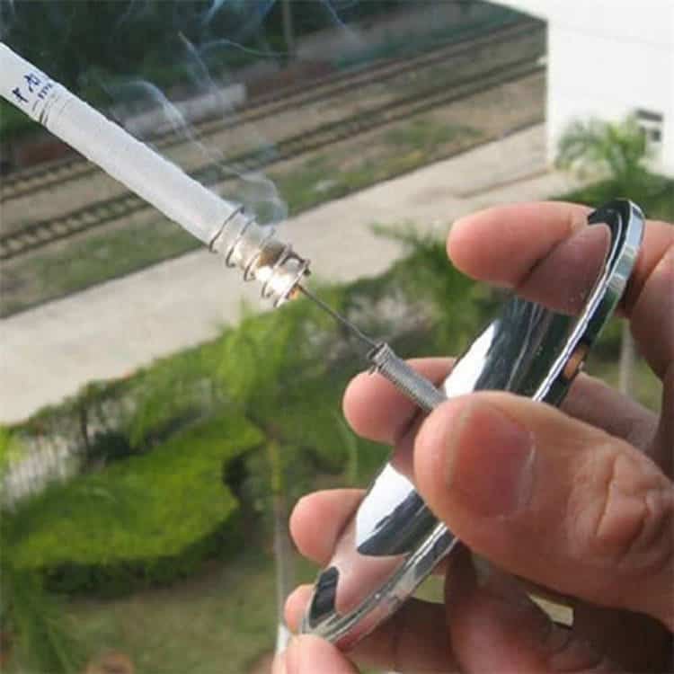 Side view of an outdoor enthusiast using the windproof solar fire starter, a premium alternative to bulk fire steel, to light a cigarette outside.
