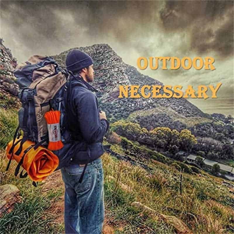 An outdoor backpacker hiking on a mountain trail with a bright orange bulk paracord bundle attached to the side of the tactical rucksack.