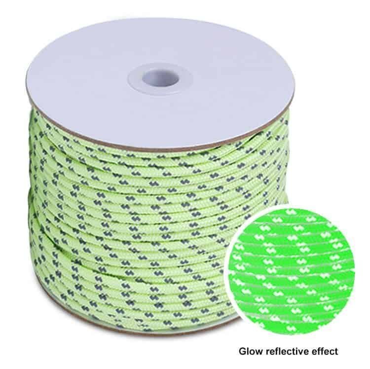 A spool of green glow-in-the-dark cord glowing brightly in the dark, highlighting UV resistant and strong bearing features from a professional paracord manufacturer.