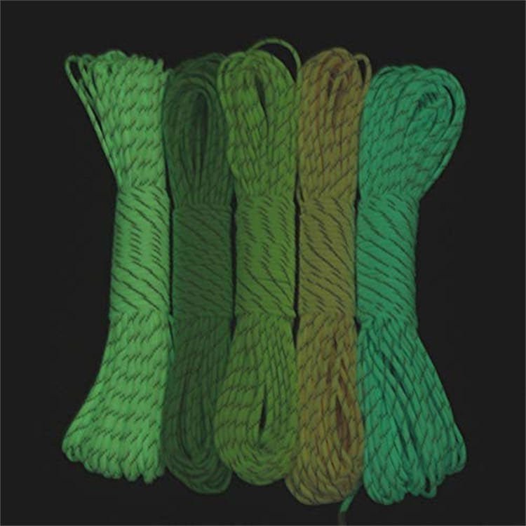 Five bundles of luminous PRD05 glow-in-the-dark utility cords illuminating in the dark, showcasing high-visibility options for wholesale paracord distributors.