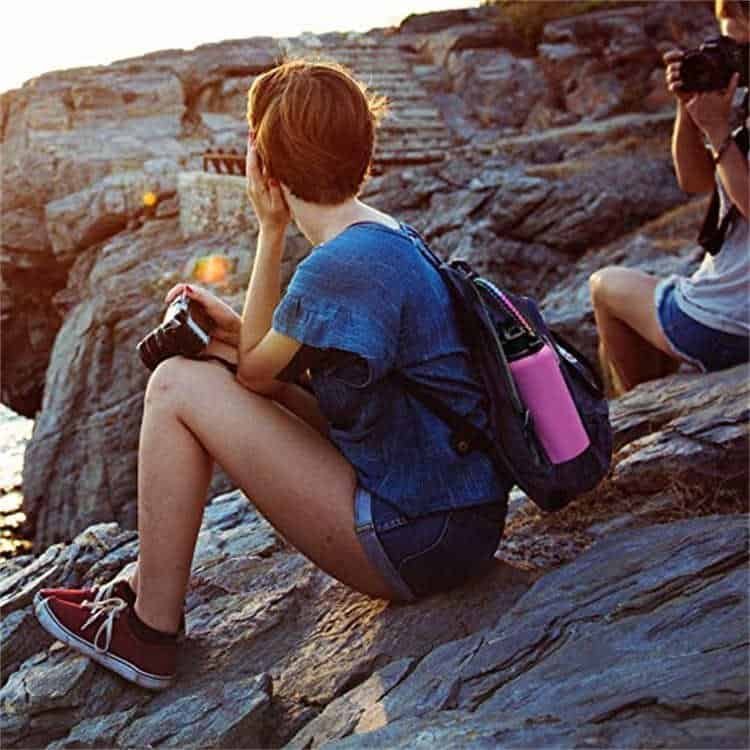 Outdoor hiker carrying a wide mouth water bottle using PH04 paracord holder bulk with survival features