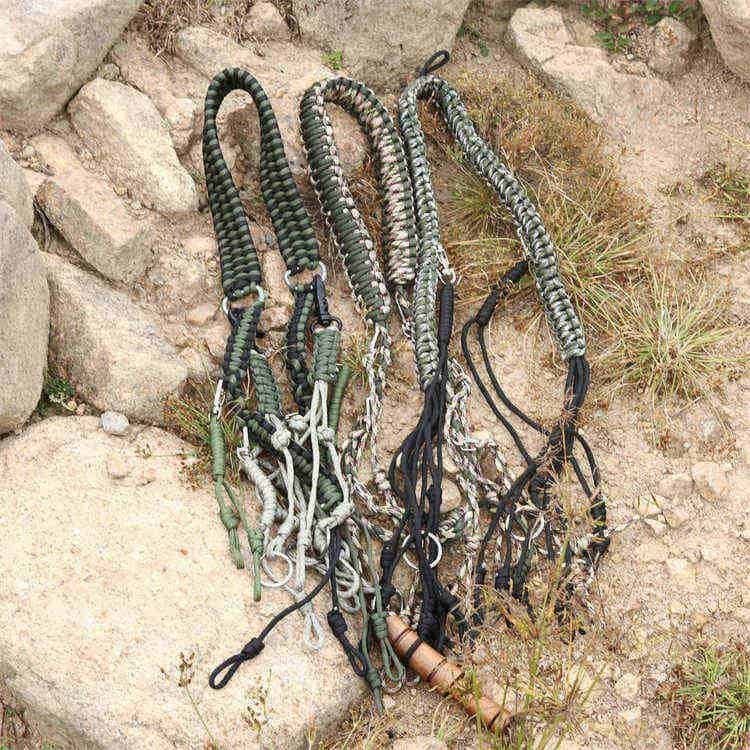 Multiple camo colorways of the PL08 wholesale paracord lanyard laid out on natural outdoor terrain.