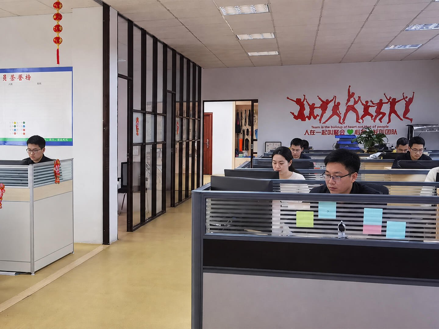 Survfire office staff working at desks with team culture wall