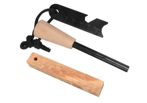 Wood handle ferro rod with ruler scraper and drilled fatwood block on white background